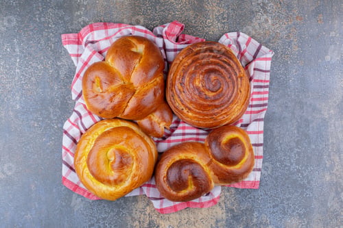 Preview: Sweet buns bundled up on a wrinkled towel on marble background