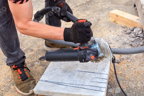 Preview: Worker using a diamond cutting disc and an angle grinder to cut the paving bar and metal plate