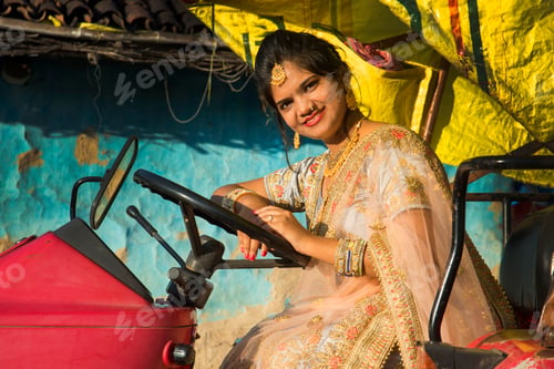 Preview: Beautiful Indian bride with tractor in village.
