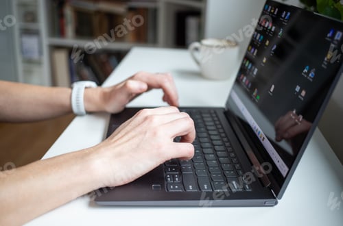 Preview: hands working on a laptop