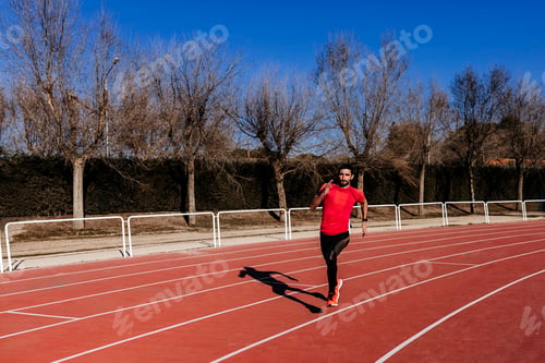 Preview: young athlete man running in the lanes. Daylight. Sports concept