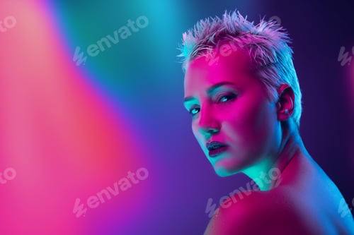Preview: Portrait of female fashion model in neon light on dark studio background