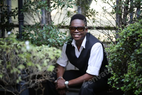 Vista previa: Portrait of young handsome afro black man posing outdoor.