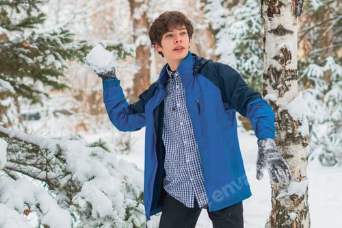 Preview: young boy playing snowball and other winter activities on a snowy day in the park f
