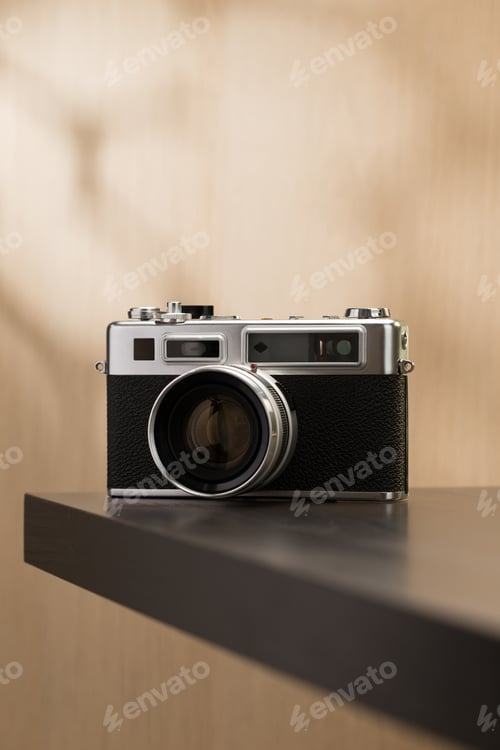 Preview: A vintage film camera sits elegantly on a table, showcasing timeless craftsmanship.