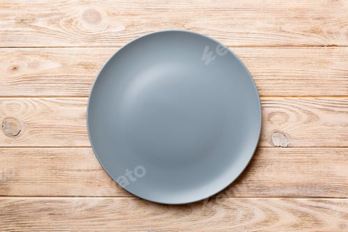 Preview: Top view of empty grey plate on wooden background. Empty space for your design