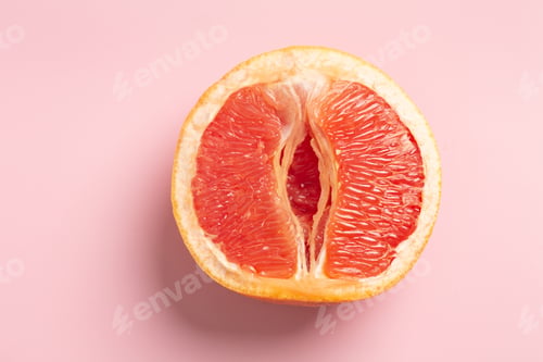 Preview: Grapefruit minimal abstract concept. Half a juicy grapefruit close up on a pink background