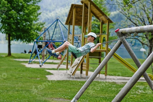 Preview: Boy swinging at playground in Hallstatt, Austria.