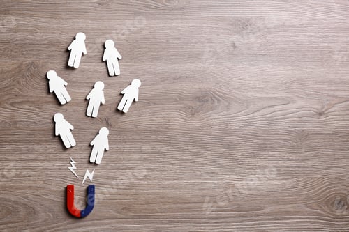 Preview: Magnet attracting paper people on wooden background, flat lay. Space for text