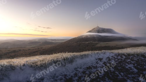 Preview: View of Puy de Dome at sunrise from Puy de Pariou with a light morning mist in early winter.