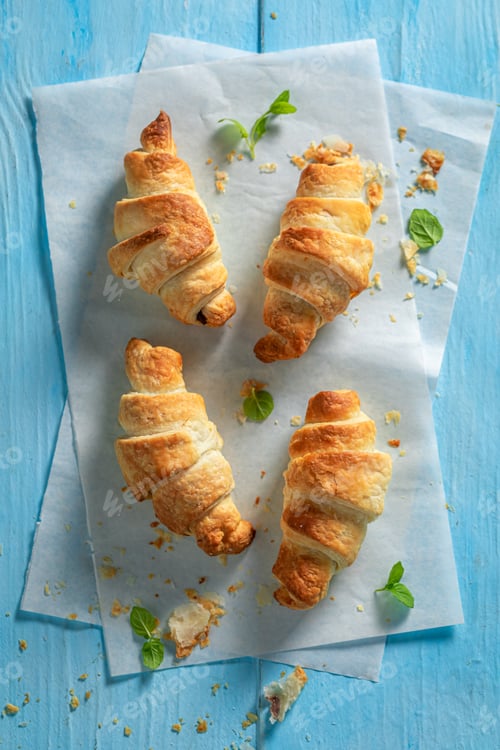 Preview: Fresh Croissants on Blue Wooden Table with Mint