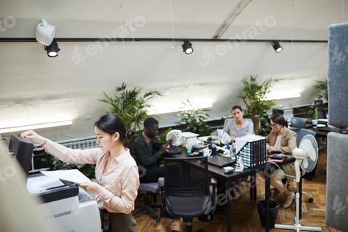 Visualização: Jovem empresária imprimindo documentos no escritório