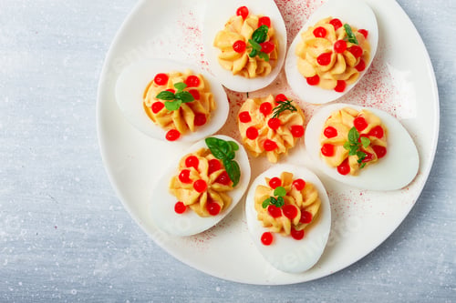 Preview: Stuffed eggs, with red caviar, micro greenery, Snack, on a white plate, top view, close-up,