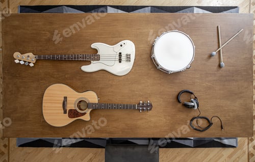 Preview: Top view of a composition of musical instruments on a wooden table in a recording studio.