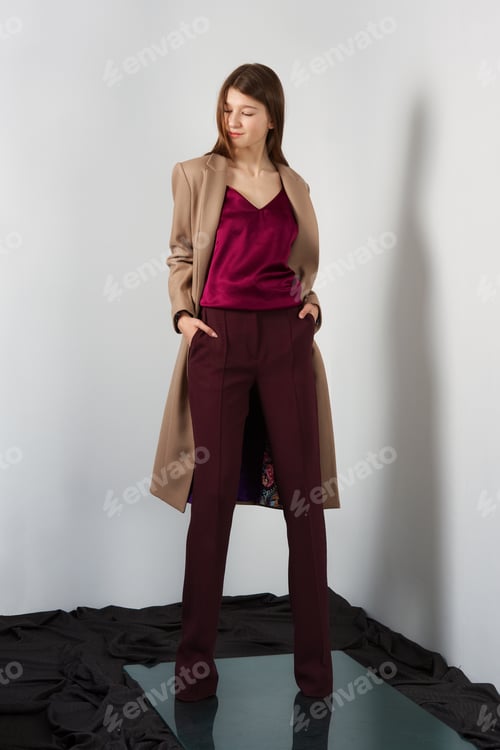 Preview: Attractive fashion model in pants, blouse on straps and light coat.