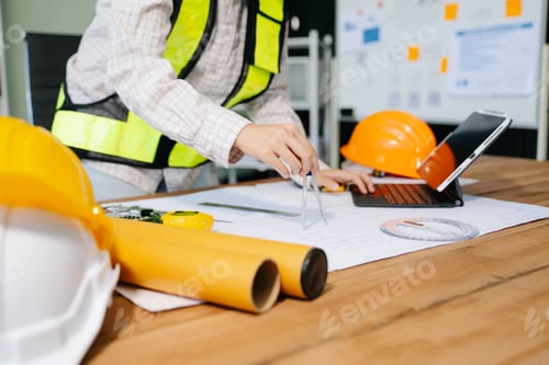 Preview: Businessman hand working and laptop with on on architectural project at construction site