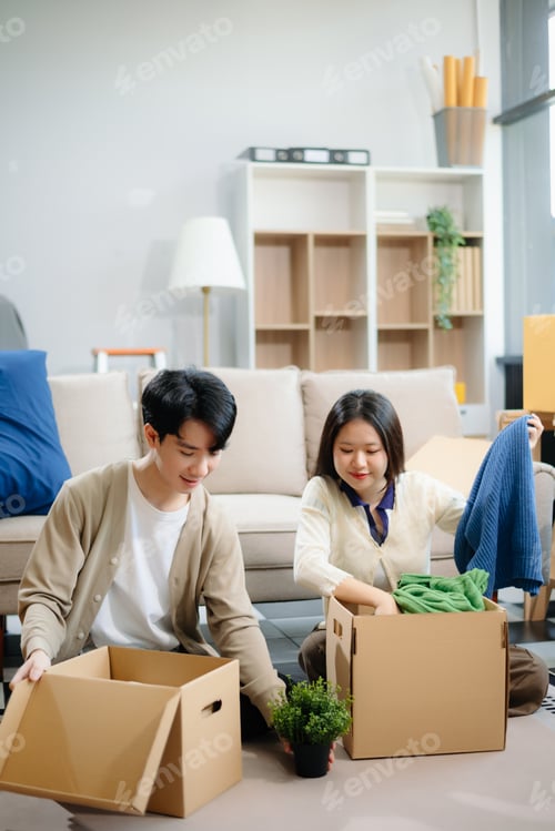 Preview: Young couple organizing belongings in a cozy home with boxes and luggage. Perfect for themes