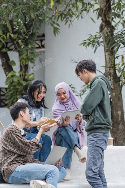 Preview: Group of Asian college student reading books and tutoring special class for exam on grass field at