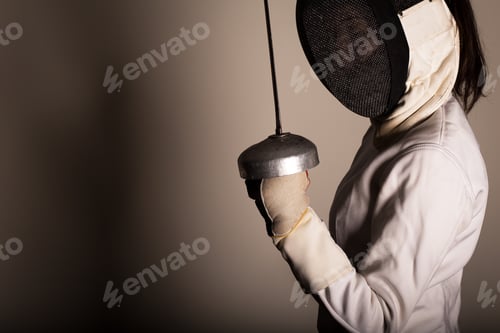 Preview: Portrait of woman wearing white fencing costume practicing with the sword.