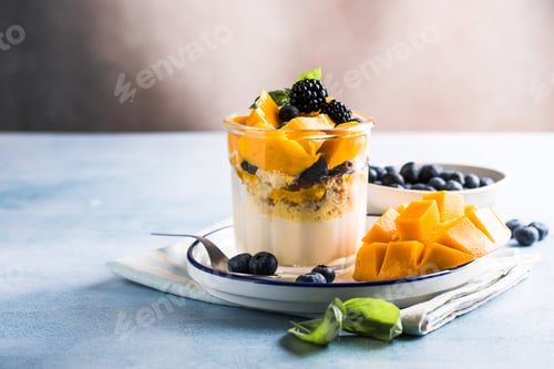 Preview: Trifle dessert with berries and cream on wooden table. Copy space