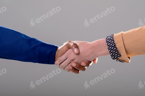 Preview: Midsection of caucasian and african american business people shaking hands on grey background