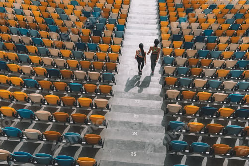 Preview: two sportswomen running on stadium stairs, running women concept