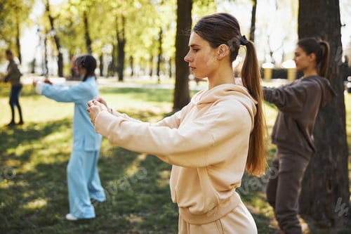 Preview: Lean woman joining her hands during tai chi activity