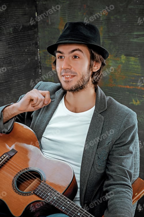 Preview: Cool Guy Sitting With Guitar On Gray Background