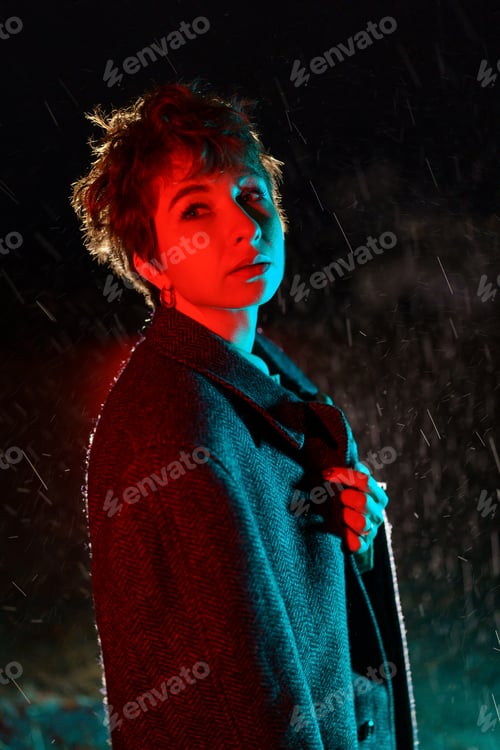 Preview: Frozen Caucasian woman as with coat draped over shoulders posing standing on street at night