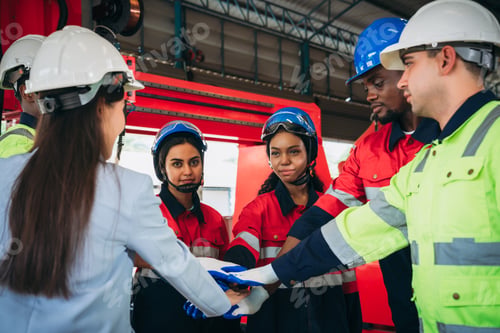 Preview: Team engineers and foreman stack hand and shake hands to show success at factory machines.