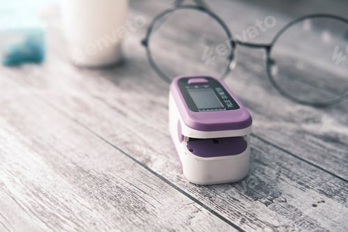 Preview: close up of pulse oximeter and a eye glass on table