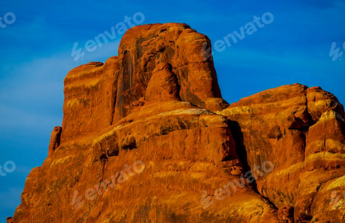 Preview: Large red sandstone boulder situated on the edge of a rural road, Arches National Park Utah