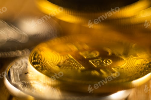Preview: Closeup shot of gold and silver bitcoins scattered on a surface illuminated with bright light