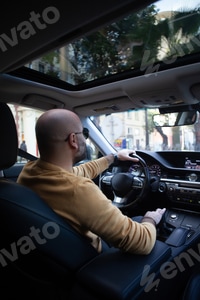 Preview: bald man driving a car
