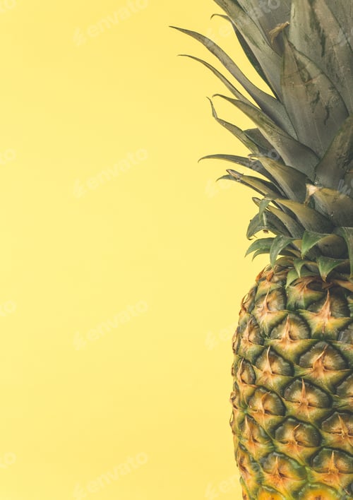 Preview: Close up of a fresh, ripe and organic pineapple on a yellow background with copy space