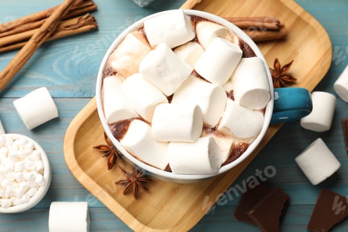 Preview: Tasty hot chocolate with marshmallows and ingredients on light blue wooden table, flat lay