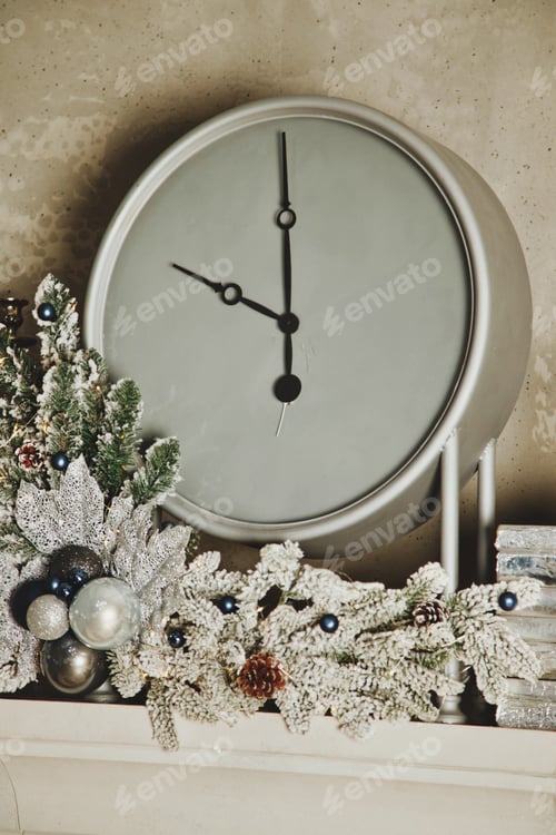 Preview: Christmas white clock with festive decorations close-up on fireplace