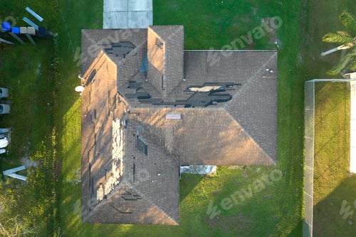 Preview: Damaged house roof with missing shingles after hurricane Ian in Florida.