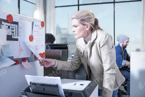 Preview: Woman looking at notice board in office