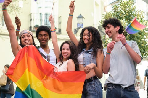 Preview: Happy multi ethnic friends having fun at LGBT pride parade waving rainbow flags
