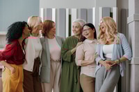 Preview: Group of happy mature women bonding and smiling while standing in the office together