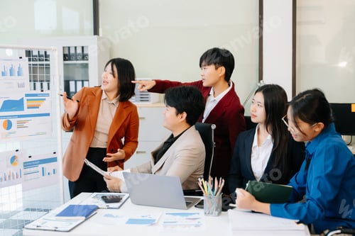 Preview: Group of diverse businesspeople using a laptop and tablet in office.