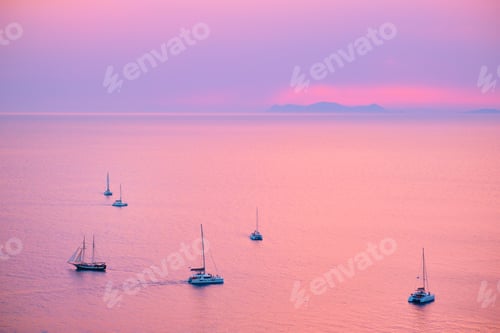 Preview: Tourist yachts boat in Aegean sea near Santorini island with tourists watching sunset viewpoint