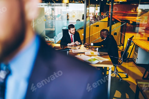 Preview: Multiethnic businessmen discussing at table