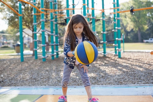Preview: Girl bouncing basketball in playground