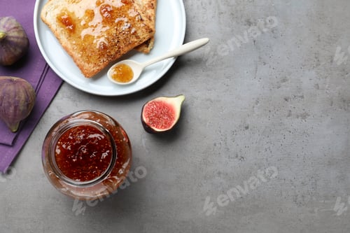 Preview: Delicious fig jam and toasts on grey table, flat lay. Space for text