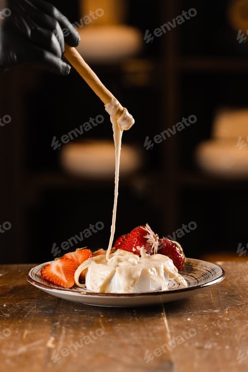 Preview: Hot Brie cheese with grissini sticks, cheese pulling, perfect Italian snack experience.