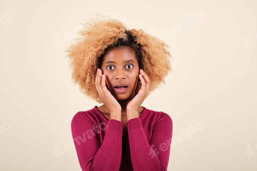 Preview: Afro woman looking with a shocked expression to the camera while standing on an isolated background.