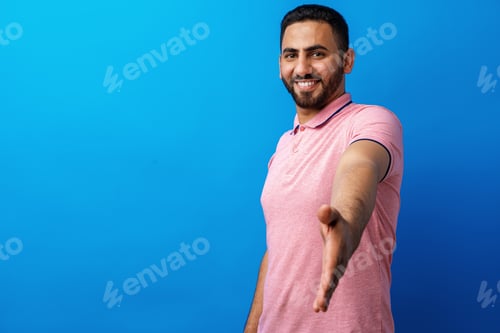 Preview: Positive arab man giving hand to handshake and greeting