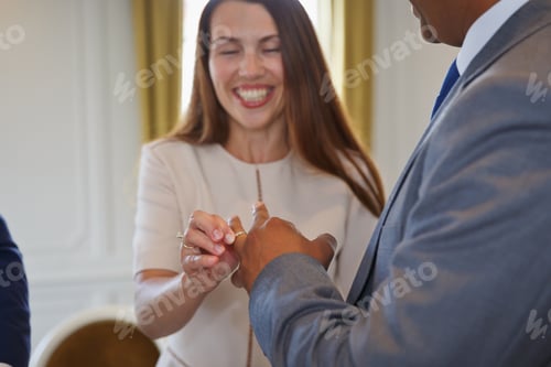 Preview: Mixed race couple holding hands and exchanging wedding rings